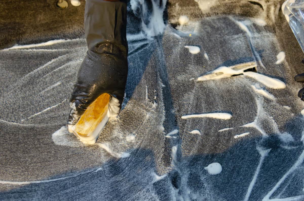 A gloved hand scrubbing with a brush during cleaning
